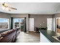 Bright living room with a ceiling fan, private balcony, and hardwood floors near dining area at 2428 W 82Nd Pl # 2D, Westminster, CO 80031
