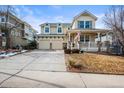 Inviting two-story home featuring a covered front porch, a two-car garage, and neat landscaping at 743 Briar Haven Dr, Castle Pines, CO 80108