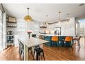 Bright, airy kitchen features a large island with bar seating, modern pendant lighting, and hardwood floors at 743 Briar Haven Dr, Castle Pines, CO 80108