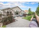 Spacious backyard with a stone patio, mature landscaping, and an outdoor dining area at 13942 W 87Th Dr, Arvada, CO 80005