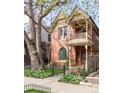 Beautiful two-story home featuring a charming balcony, mature tree, and manicured landscaping at 3147 Vallejo St, Denver, CO 80211