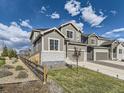 A cozy home with a fenced yard, complemented by lush green grass, under a beautiful blue sky at 917 White Leaf Cir, Castle Rock, CO 80108