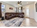 Bright living room featuring wood floors, a sectional sofa, and a glass paneled door at 917 White Leaf Cir, Castle Rock, CO 80108