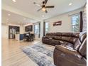 Open-concept living room connects to the kitchen, featuring wood floors, a large couch and ample natural light at 917 White Leaf Cir, Castle Rock, CO 80108