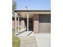 Close-up of home's entryway showing the covered porch, brick detail, and attached garage at 3025 Forest St, Denver, CO 80207