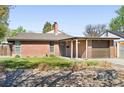 Single-story brick home with a tidy front yard, covered porch, and attached garage, ready for move-in at 3025 Forest St, Denver, CO 80207