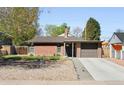 Charming brick home featuring a well-maintained front yard and attached one-car garage at 3025 Forest St, Denver, CO 80207