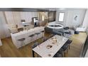 Open floor plan includes a dining table, kitchen island with bar stools, and modern lighting fixtures at 621 Lombardi Cir, Louisville, CO 80027