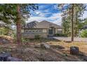 Beautiful home featuring stone accents, a well-manicured lawn, and mature trees at 31042 Wildwoods, Evergreen, CO 80439