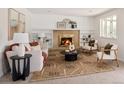 Inviting living room with a brick fireplace, built-in shelves, neutral tones, and lots of natural light at 6463 S Vance St, Littleton, CO 80123