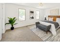 Bright main bedroom with natural light, carpet floors, modern decor, and a comfortable seating area at 6463 S Vance St, Littleton, CO 80123