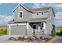 Charming two-story home featuring a gray exterior, a two-car garage and a welcoming front porch at 907 W Beverly St, Elizabeth, CO 80107