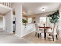 Dining room features tile flooring, a plant, and easy access to kitchen and staircase at 87 Macon Ct, Aurora, CO 80010