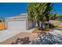 Charming home exterior featuring a well-maintained lawn, mature tree, two-car garage, and inviting facade at 87 Macon Ct, Aurora, CO 80010