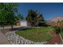 Beautiful home with a well-manicured front yard, rock landscaping, mature trees, and a two-car garage at 87 Macon Ct, Aurora, CO 80010