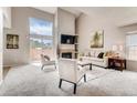 Bright living room with fireplace, vaulted ceilings, and sliding glass doors for natural light at 87 Macon Ct, Aurora, CO 80010