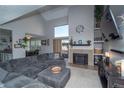 Cozy living room showcasing a vaulted ceiling, fireplace and slider doors to the backyard at 87 Macon Ct, Aurora, CO 80010