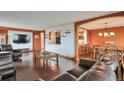Inviting living room featuring hardwood floors, TV, and seamless access to dining area at 3131 E Alameda Ave # 704, Denver, CO 80209
