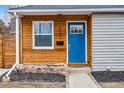 Inviting front entrance with a bright blue door and eye-catching wood panel siding at 2332 Hanover St, Aurora, CO 80010