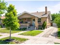 Charming brick home with a well-manicured front yard and a long driveway at 2026 S Lincoln St, Denver, CO 80210