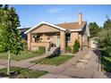 Charming brick home with a cozy front porch, a well-manicured lawn, and private driveway at 2026 S Lincoln St, Denver, CO 80210