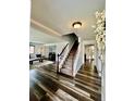 Inviting foyer featuring wood floors, a staircase, and views into the living and dining areas at 4640 W Princeton Ave, Denver, CO 80236