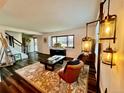 Cozy living room with wood floors, a large window, comfortable seating, and stylish light fixtures at 4640 W Princeton Ave, Denver, CO 80236