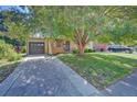 Ranch style home with attached garage, large tree, and well maintained lawn at 6054 Iris Way, Arvada, CO 80004