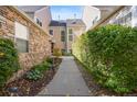 A lovely walkway between townhouses surrounded by lush greenery and mature hedges, leading to a welcoming entrance at 10000 E Yale Ave # 41, Denver, CO 80231