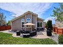 Backyard featuring a spacious patio with outdoor seating, perfect for entertaining, surrounded by a lush green lawn and mature trees at 18477 E Amherst Dr, Aurora, CO 80013