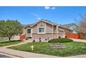 Well maintained home featuring neutral siding, manicured lawn, mature landscaping, and brick accents, creating a welcoming curb appeal at 18477 E Amherst Dr, Aurora, CO 80013