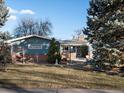 Ranch style home with brick and siding exterior, landscaping, and a two-car garage at 1750 Vance St, Lakewood, CO 80214