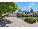 Home exterior features a driveway leading to a two-car garage and a well-kept front lawn at 2554 S Laredo Ct, Aurora, CO 80013
