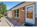 Home showcasing a well-lit front entrance, brick facade, and manicured landscape at 2554 S Laredo Ct, Aurora, CO 80013