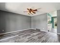 Living room with wood-look floors, gray walls, ceiling fan and open view to the kitchen at 2554 S Laredo Ct, Aurora, CO 80013