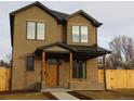 Inviting two-story home with a brick and stucco facade, featuring a covered porch and well-maintained landscaping at 1970 S Logan St, Denver, CO 80210