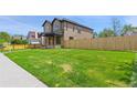 Expansive green lawn surrounding a newly built home, partially enclosed by a wooden fence enhancing its curb appeal at 1970 S Logan St, Denver, CO 80210