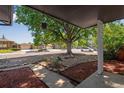 View of the front yard with mature tree providing shade, stone landscaping, and a sidewalk at 10851 E Iliff Pl, Aurora, CO 80014