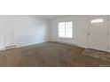 Bright living room featuring neutral carpet, white walls, and a large window offering plenty of natural light at 3577 S Ouray Cir, Aurora, CO 80013