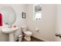 Well-lit powder room with pedestal sink, modern fixtures, and a clean design at 947 W Beverly St, Elizabeth, CO 80107