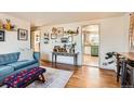 Open-concept living room with hardwood floors, gallery wall, and view into the kitchen at 4332 Bruce Randolph Ave, Denver, CO 80207