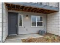 Inviting townhome entrance featuring a gray front door, a window with blinds, and an exterior air conditioning unit at 479 Interlocken Blvd # 105, Broomfield, CO 80021