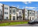 Modern townhome showcasing diverse exterior finishes, landscaping, and a parked car in front of the property at 479 Interlocken Blvd # 105, Broomfield, CO 80021