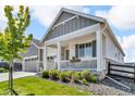 Inviting front porch with stone accents, complemented by lush greenery and a well-kept lawn at 23913 E Swallow Cir, Aurora, CO 80016