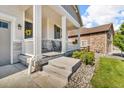 Covered porch featuring elegant columns, seating, and a welcoming entrance with a decorative wreath at 23913 E Swallow Cir, Aurora, CO 80016
