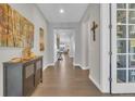 Inviting hallway with hardwood floors, neutral walls, and decorative accents leading to the living area at 23913 E Swallow Cir, Aurora, CO 80016