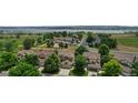 Aerial view of a residential neighborhood with a lake in the background, featuring well-maintained homes with lush landscaping at 8532 W Eden Dr, Littleton, CO 80127