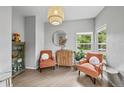 Cozy sitting area featuring stylish chairs, modern lighting, and a curated display cabinet, creating a welcoming atmosphere at 8532 W Eden Dr, Littleton, CO 80127