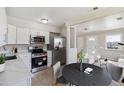 Bright kitchen with stainless steel appliances, white cabinetry, and an adjacent dining area at 2340 Geneva, Aurora, CO 80010