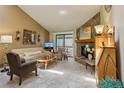 Inviting living room features a stone fireplace, plush carpeting, and sliding doors to a balcony at 7780 W 87Th Dr # E, Arvada, CO 80005